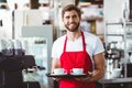 Handsome barista holding two cups of coffee