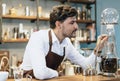 Handsome Barista man owner looking use cold brew coffee tower in coffee shop restaurant. Man working with small business owner or Royalty Free Stock Photo