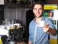 Handsome barista offering a cup of coffee Royalty Free Stock Photo