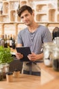 Handsome barista working in a cozy coffee house