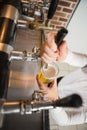 Handsome barman pouring a pint of beer Royalty Free Stock Photo