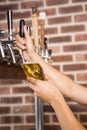 Handsome barman pouring a pint of beer Royalty Free Stock Photo