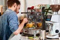 Handsome barman preparing ground coffee for customer in coffee shop. Royalty Free Stock Photo