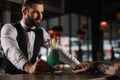 handsome bartender giving alcohol drink to girl