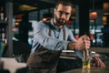 handsome bartender preparing alcohol drink and looking