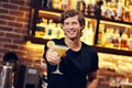 Handsome bartender serving cocktails in a pub