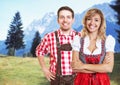 Handsome bavarian man and beautiful blonde woman with dirndl celebrating the oktoberfest Royalty Free Stock Photo