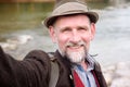 Bavarian man in his 50s standing by river and taking a selfie Royalty Free Stock Photo