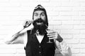 Handsome bearded aviator man with long beard and mustache on happy face holding glass of alcoholic cocktail in vintage Royalty Free Stock Photo