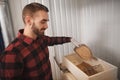 Brewer pouring barley seeds into grain mill at his brewery