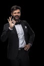 Handsome bearded businessman in bow tie winking and showing ok sign Royalty Free Stock Photo