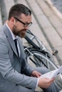 handsome bearded businessman reading newspaper on stairs Royalty Free Stock Photo