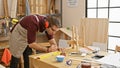 Handsome bearded craftsman using tools in a well-organized woodworking workshop Royalty Free Stock Photo