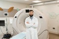 Handsome bearded doctor in medical robe with computed tomograph for obtain detailed internal images of the body of Royalty Free Stock Photo