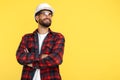 Handsome bearded engineer or constructor man in plai shirt standing over yellow background. Looking away. Royalty Free Stock Photo