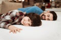 Handsome bearded father with young son is testing mattress for softness.