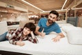 Handsome bearded father with young son is testing mattress for softness. Royalty Free Stock Photo