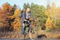 Handsome bearded hipster man in casual wear with backpack riding bicycle in autumn park or forest. Discovery beautiful fall season