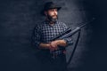 Handsome bearded hunter traveler in a fleece shirt and hat holds rifle with a sight.