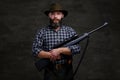 Handsome bearded hunter traveler in a fleece shirt and hat holds rifle with a sight.