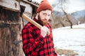 Handsome bearded man with axe in village