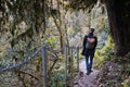 Handsome, bearded man in coat with backpack enjoys stroll through beautiful autumn yellow and orange forest. Tourist Royalty Free Stock Photo