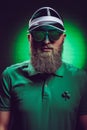 handsome bearded man in green polo shirt with shamrock