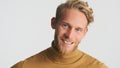 Handsome bearded man happily looking in camera over white background. Cheerful male model posing in studio Royalty Free Stock Photo