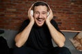 Handsome bearded man in headphones listening to music at home. Music. Half-length portrait of young smiling guy in Royalty Free Stock Photo