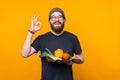 Handsome bearded man holding a cutting board with some vegetables is showing ok gesture. Royalty Free Stock Photo