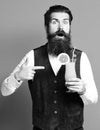 Handsome bearded man with long beard and mustache has stylish hair on surprised face holding glass of alcoholic cocktail Royalty Free Stock Photo