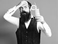 Handsome bearded man with long beard and mustache has stylish hair on surprised face holding glass of alcoholic cocktail Royalty Free Stock Photo