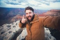 Handsome bearded man makes selfie photo on travel hiking at Grand Canyon in Arizona Royalty Free Stock Photo