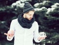 Handsome man with moneybox and cup in winter outdoor