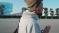 Young relaxed townsman is walking outdoors alone and drinking water