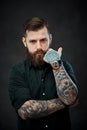 Handsome bearded man with tattoos on his hands looks at the camera with a thoughtful look Royalty Free Stock Photo