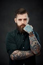 Handsome bearded man with tattoos on his hands looks at the camera with a thoughtful look Royalty Free Stock Photo