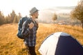 Handsome bearded man tourist exploring new places on top of mountains. Hiker man in hat with backpack happy to see sunrise