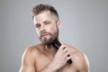 Handsome bearded man trimming his beard with a trimmer Royalty Free Stock Photo