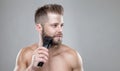 Handsome bearded man trimming his beard with a trimmer Royalty Free Stock Photo