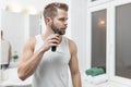 Handsome bearded man trimming his beard with a trimmer Royalty Free Stock Photo