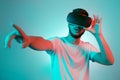 Handsome bearded man trying VR headset and poniting. Young man exploring another world with virtual reality goggles on