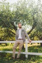 Handsome bearded man in vintage clothing. Portrait stylish groom in plaid jacket on his wedding day in the park. Rustic hipster