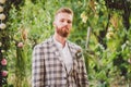 Handsome bearded man in vintage clothing. Portrait stylish groom in plaid jacket on his wedding day in the park. Rustic hipster