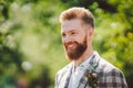 Handsome bearded man in vintage clothing. Portrait stylish groom in plaid jacket on his wedding day in the park. Rustic hipster