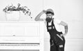 Handsome bearded mover posing next to retro piano isolated on white background. Small break from tiresome work