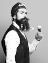 Handsome bearded pilot or aviator man with long beard and mustache on funny face holding glass of alcoholic shot in Royalty Free Stock Photo