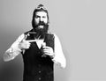 Handsome bearded pilot or aviator man with long beard and mustache on funny face holding glass of alcoholic shot in Royalty Free Stock Photo