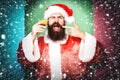 Handsome bearded santa claus man with long beard on funny face holding glass of alcoholic beverage in christmas or xmas