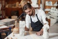 Bearded sculptor measures stone woman torso to make copy of it from limestone at creative studio.